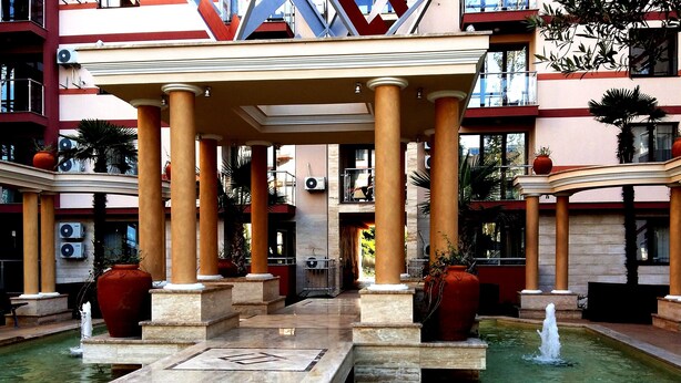 A courtyard with a central fountain, surrounded by columns and potted plants. - Menada Apartments in Tarsis Nova Complex (Sunny Beach)