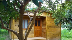 A small wooden cabin with a front door, a window, and a porch.
