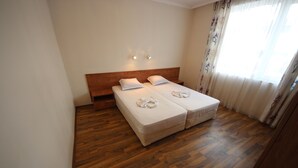 A double bed with white linens, a wooden headboard, and a small bedside table. - Menada Apartments in Azzuro Hotel (Sunny Beach)