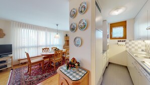 Un apartamento moderno con comedor, cocina y sala de estar con televisor.