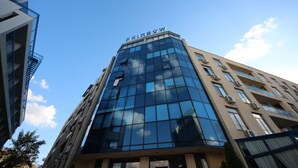 A modern building with a glass facade and the name "Rainbow" at the top. - Menada Apartments in Rainbow 1 Complex (Sunny Beach)