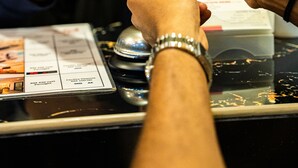 Una persona entregando una tarjeta a otra persona en un mostrador.