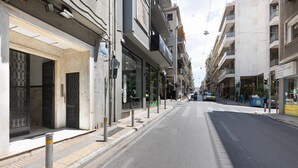 Una vista di strada con un negozio chiuso sulla sinistra e una strada libera davanti.