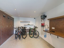 Zona de almacenamiento de bicicletas con varias bicicletas, un letrero de punto de servicio y una estación de agua.