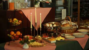 Ein reichhaltiges Buffet mit verschiedenen Speisen, Kerzen und einem Obstkorb.
