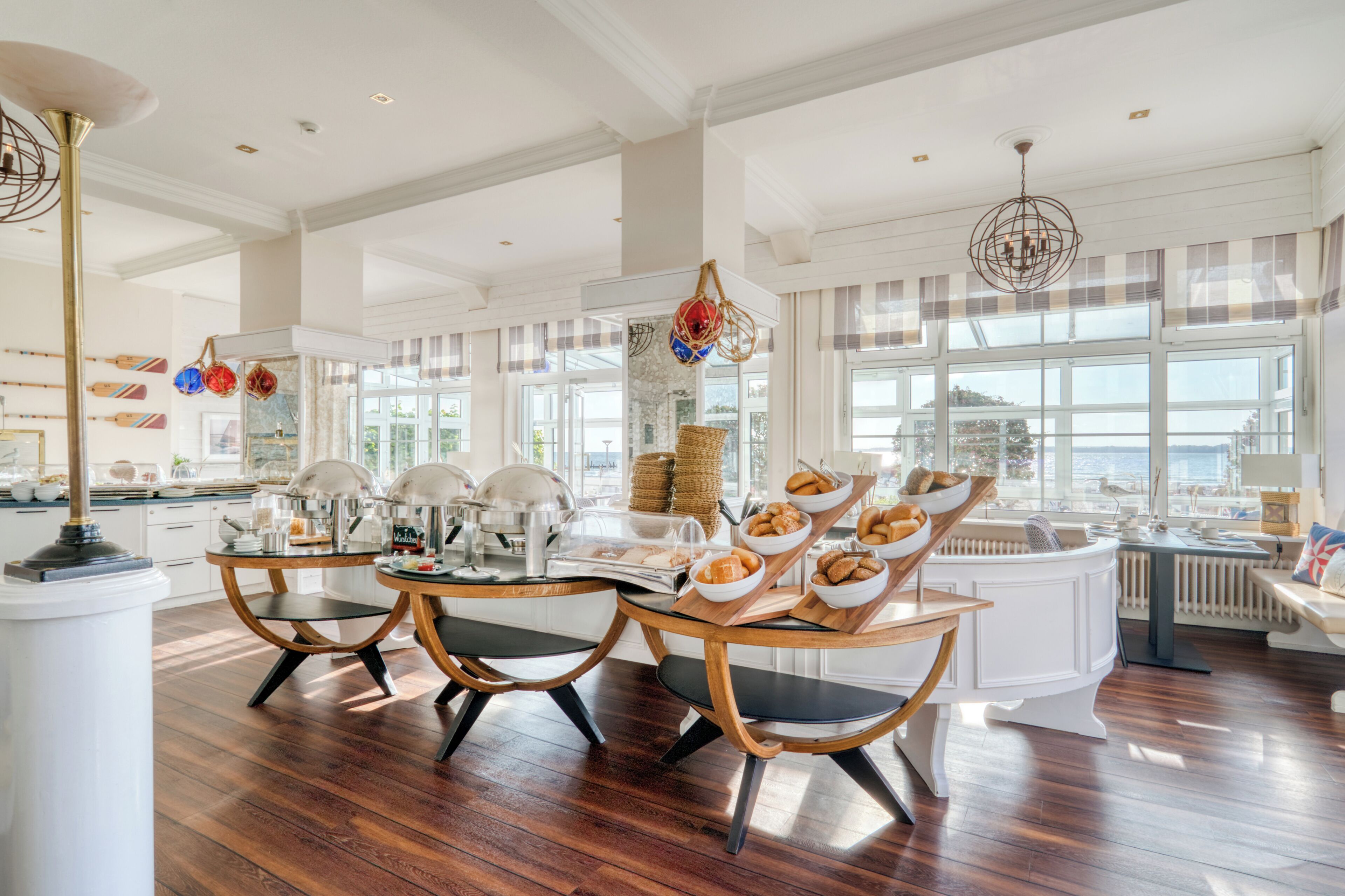 A spacious kitchen with a large island, modern appliances, and a view of the sea.