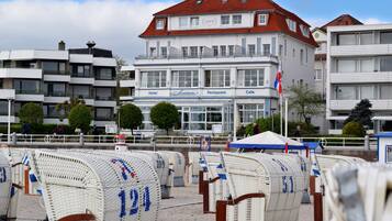 A hotel with a restaurant and cafe, featuring a red roof and multiple windows.