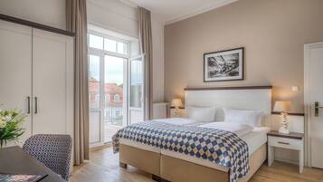 Una camera d'albergo con un letto grande, una scrivania e vista sugli edifici.
