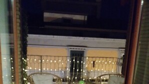 A balcony with wicker chairs and a table, decorated with string lights. - A Casa Carmen (Aversa)