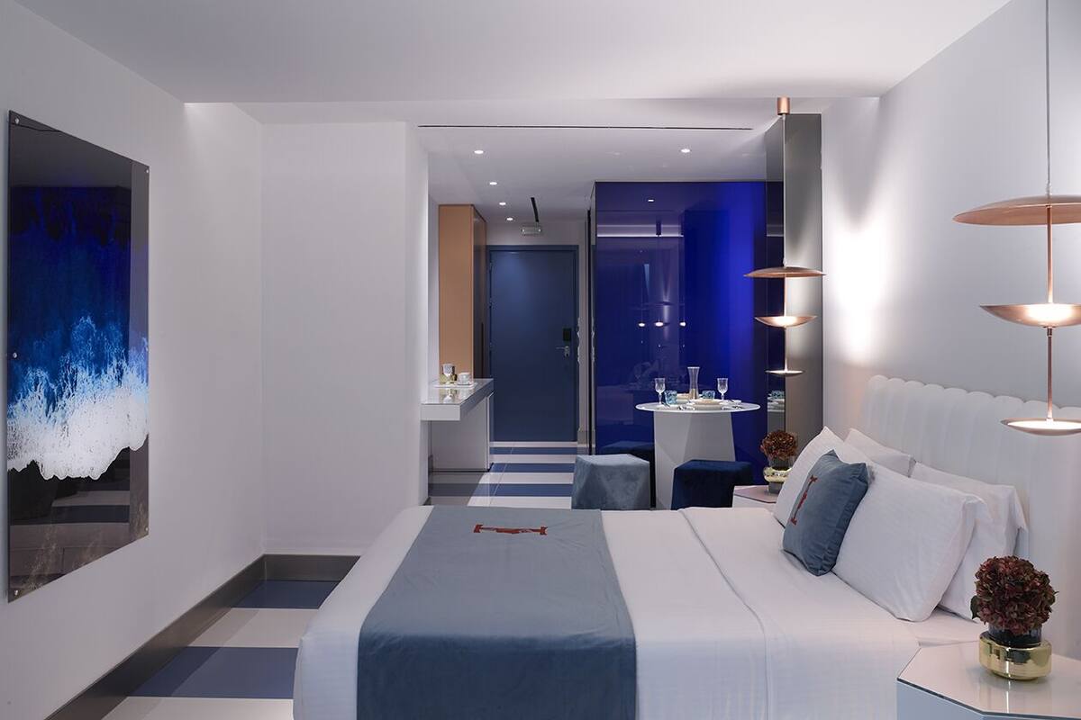 Une chambre d’hôtel moderne avec un grand lit, un bureau et une vue sur la salle de bain.