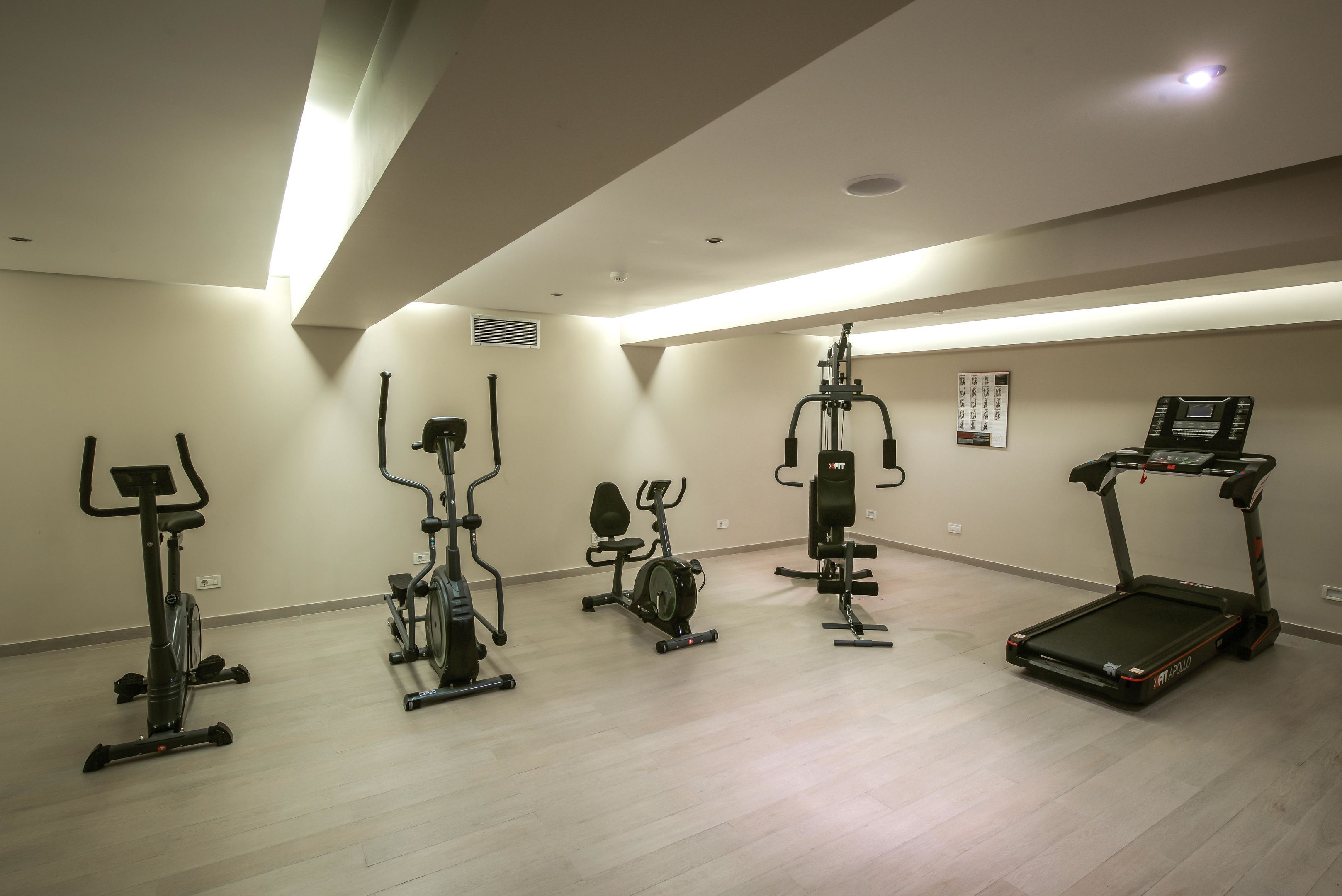 Ein Fitnessstudio mit unterschiedlichen Trainingsgeräten, darunter Laufbänder, Ergometer und Crosstrainer.