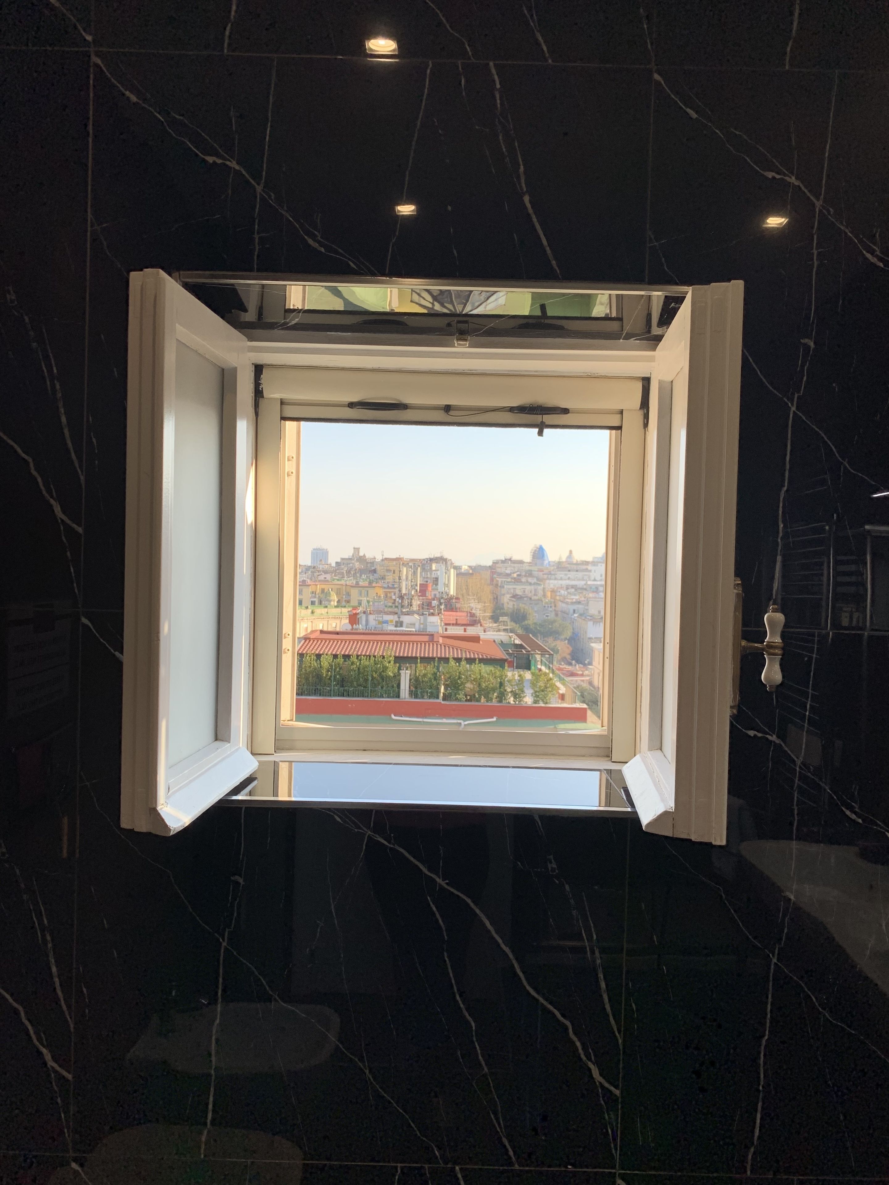 A room with a large window overlooking a cityscape. - Di Palma Suite Museum (Naples)