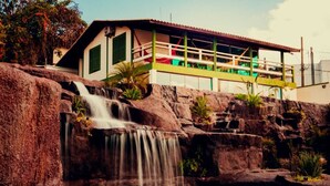 A building with a waterfall and pool. - Summit Lago Hotel (Lambari)