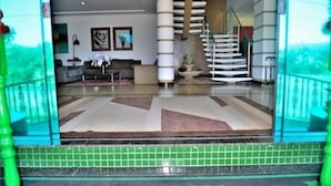 A hotel lobby with a staircase, a reception desk, and a tiled floor. - Summit Lago Hotel (Lambari)