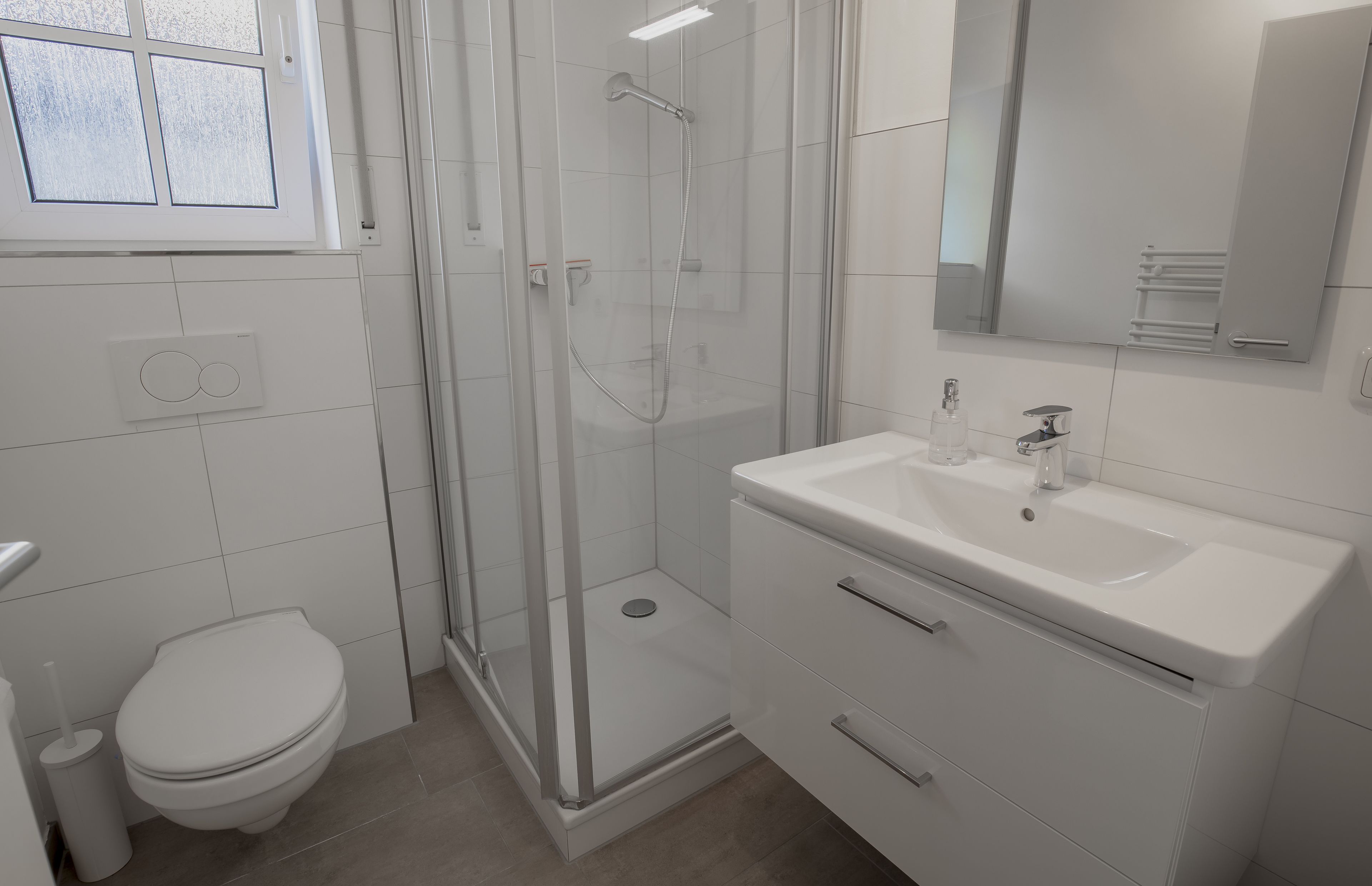 Un bagno moderno con WC, doccia e lavandino.