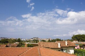 A residential area with terracotta-tiled roofs, a clear sky, and distant buildings. - Villa Serena (Portoferraio)