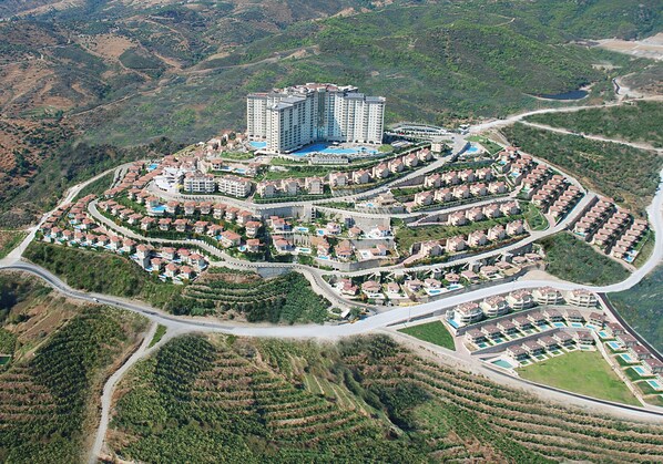 A large resort with multiple buildings, a central pool, and terraced landscaping. - Goldcity Holiday Homes (Alanya)