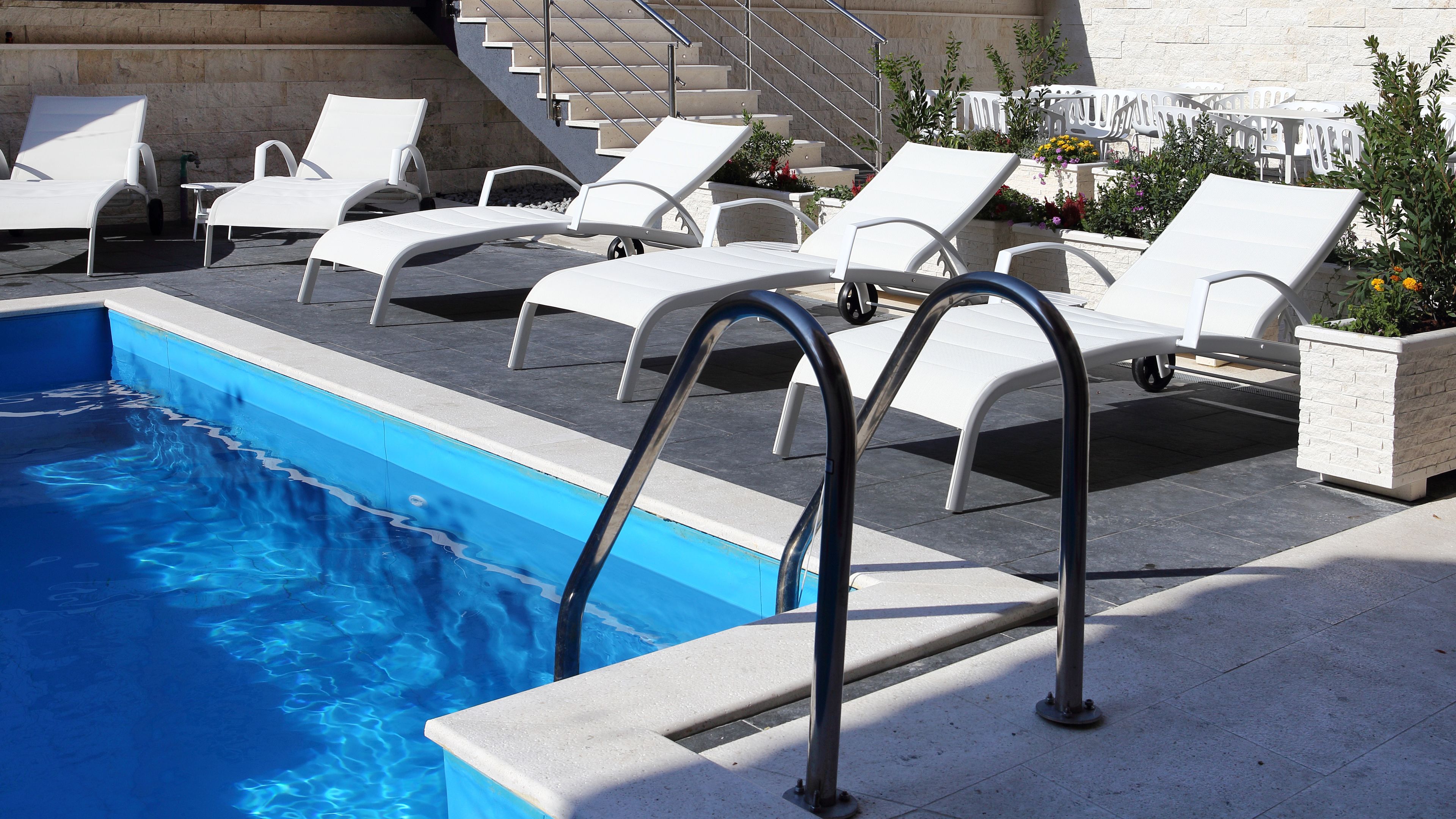 Ein Poolbereich mit Liegestühlen.