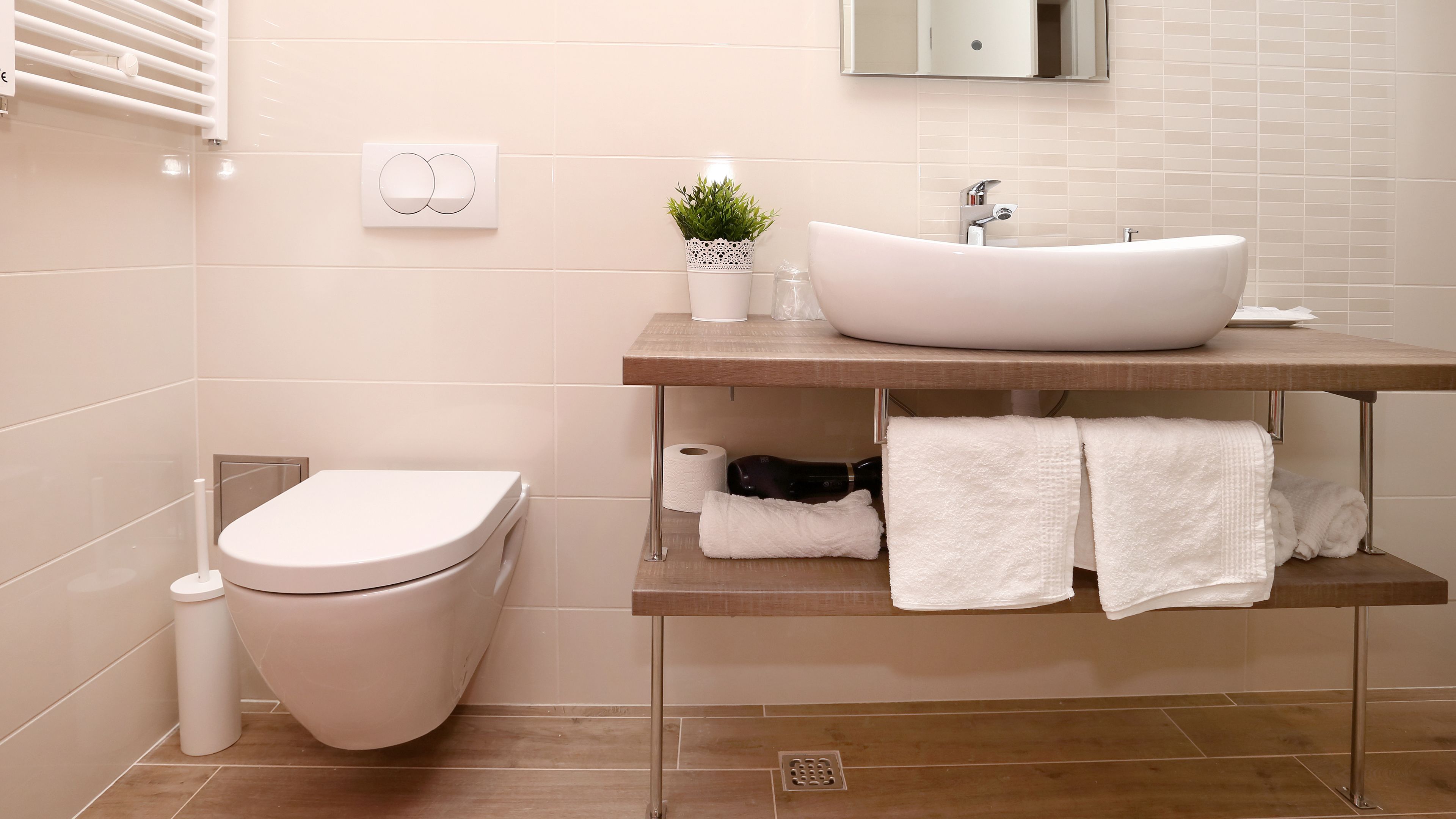 A modern bathroom with a toilet, sink, and towel rack.