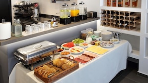 A buffet setup with various food items, beverages, and a coffee machine. - Villa M (Split)