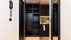 A modern interior with a wooden floor, a black telephone, and a kitchen area with a sink and countertop. - Hilltop Apartments City Centre (Tallinn)
