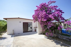 A modern building with a white exterior, a brown door, and a small porch area. - Villa Leo (Portoferraio)