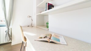 A minimalist room with a chair, a desk, and a bookshelf. - Italianway Comfort - Bligny 19 B (Milan)