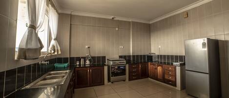 Una cocina moderna con un refrigerador de acero inoxidable, un horno empotrado y un microondas.