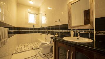 Une salle de bain avec des toilettes, un lavabo et une baignoire.
