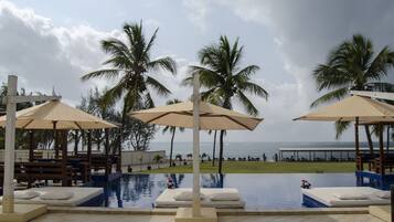 Una piscina al aire libre, camas de piscina gratis, sombrillas