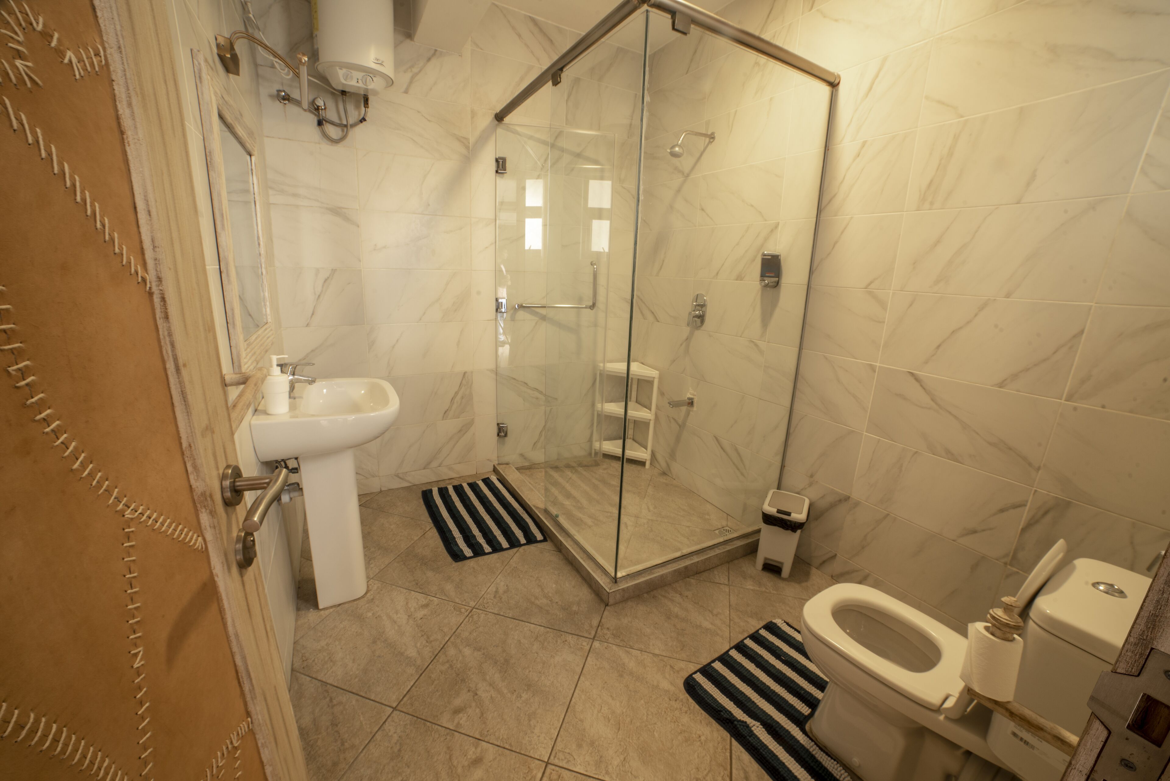 Une salle de bain dotée d’une douche à parois de verre, d’un lavabo, de toilettes et d’un bidet.
