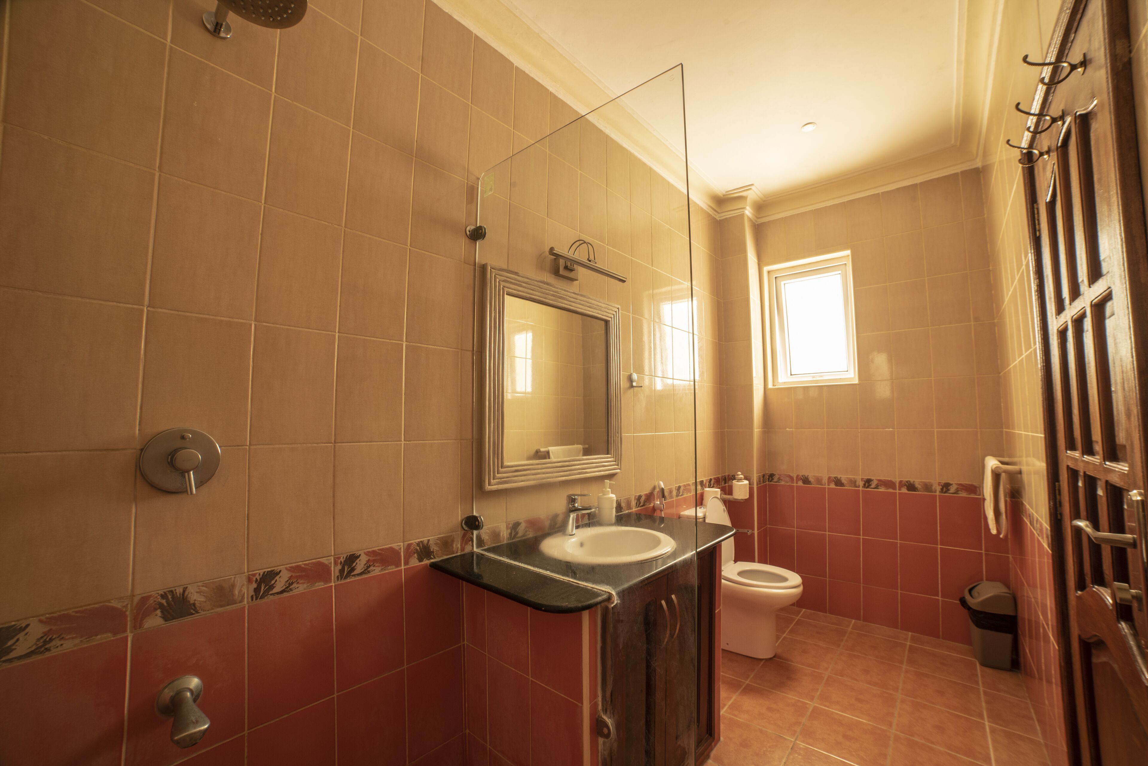 A bathroom with a sink, mirror, toilet, and shower.