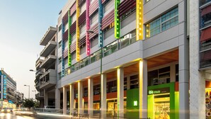 Um edifício moderno de vários andares, com varandas e grandes janelas.