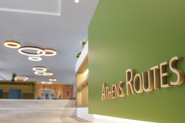 A reception area with a green wall and the sign "ATHENS ROUTES". - ibis Styles Athens Routes (Athens)