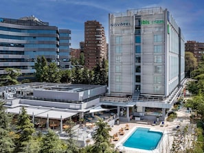 Ein Hotel mit Pool auf dem Dach, Sitzgelegenheiten im Freien und modernem architektonischen Design.