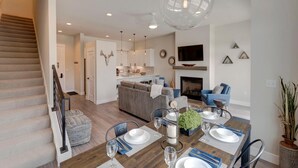A modern kitchen with white cabinets, a central island, and pendant lighting. - Downtown WP Loft 17 I Huge Hot Tub I Views I Bunk Beds I Game Console I Discounted Attractions (Winter Park)