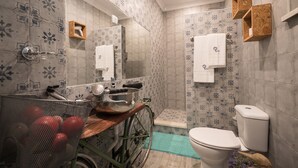 Bagno con toilette, lavabo, specchio e zona doccia.
