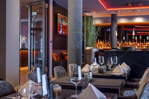 Un restaurant doté d’un bar, de tables et d’un décor intérieur moderne.