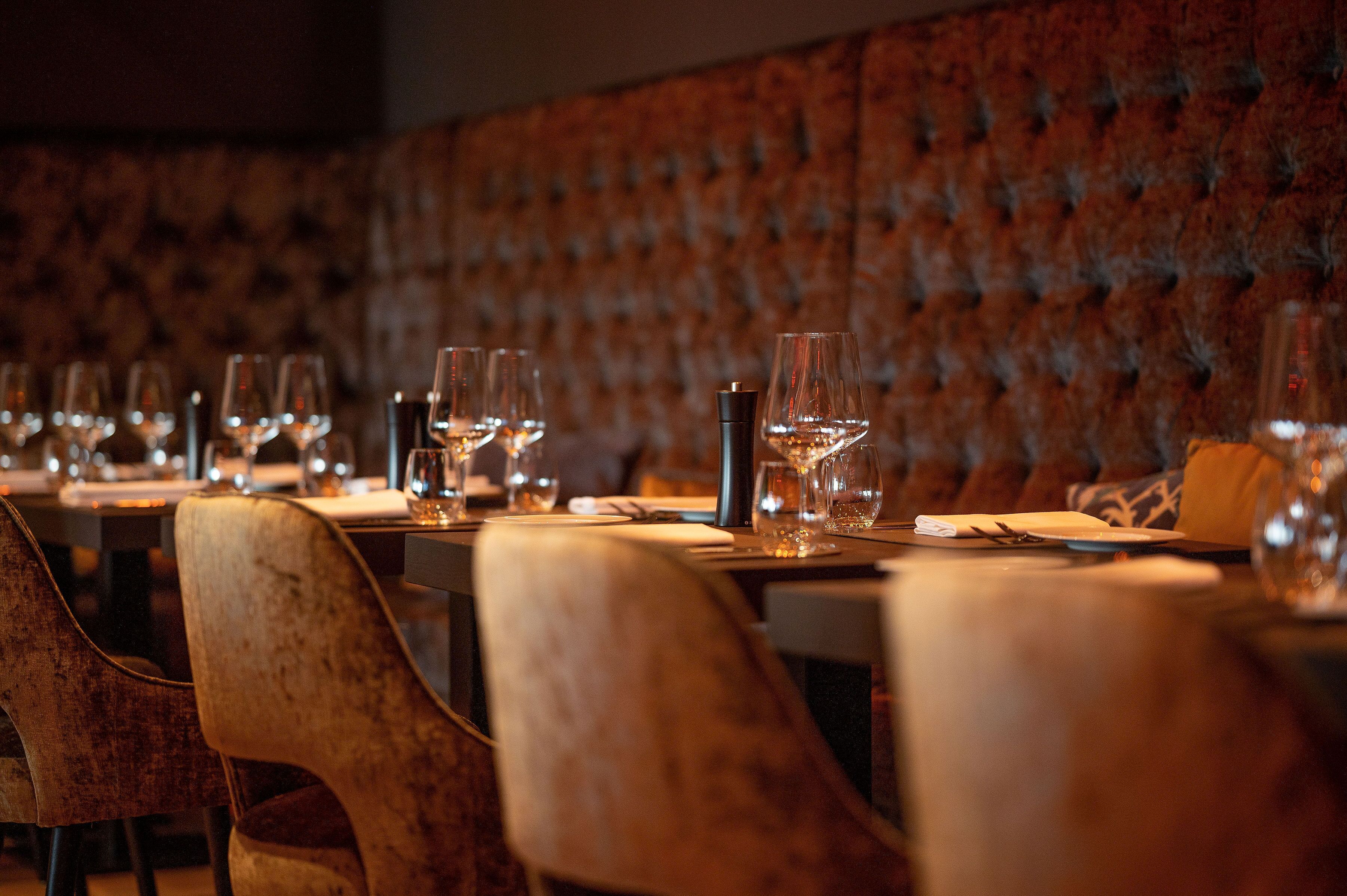 Een restaurant met fluwelen wanden en houten stoelen.