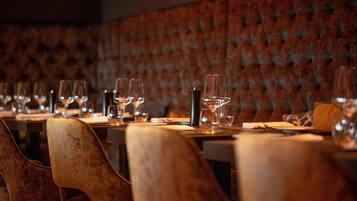 Een restaurant met fluwelen wanden en houten stoelen.