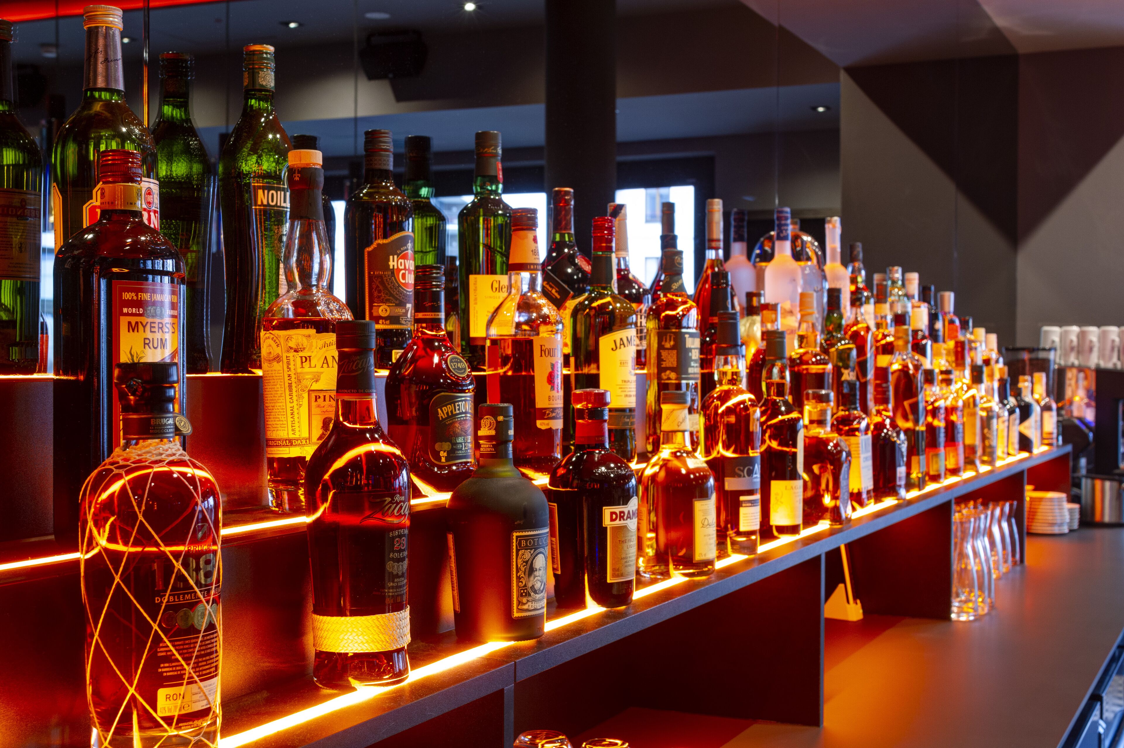 A bar with a variety of liquor bottles neatly arranged on shelves.
