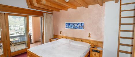 A bedroom with a wooden bed, a nightstand, a painting, and a view of a balcony.