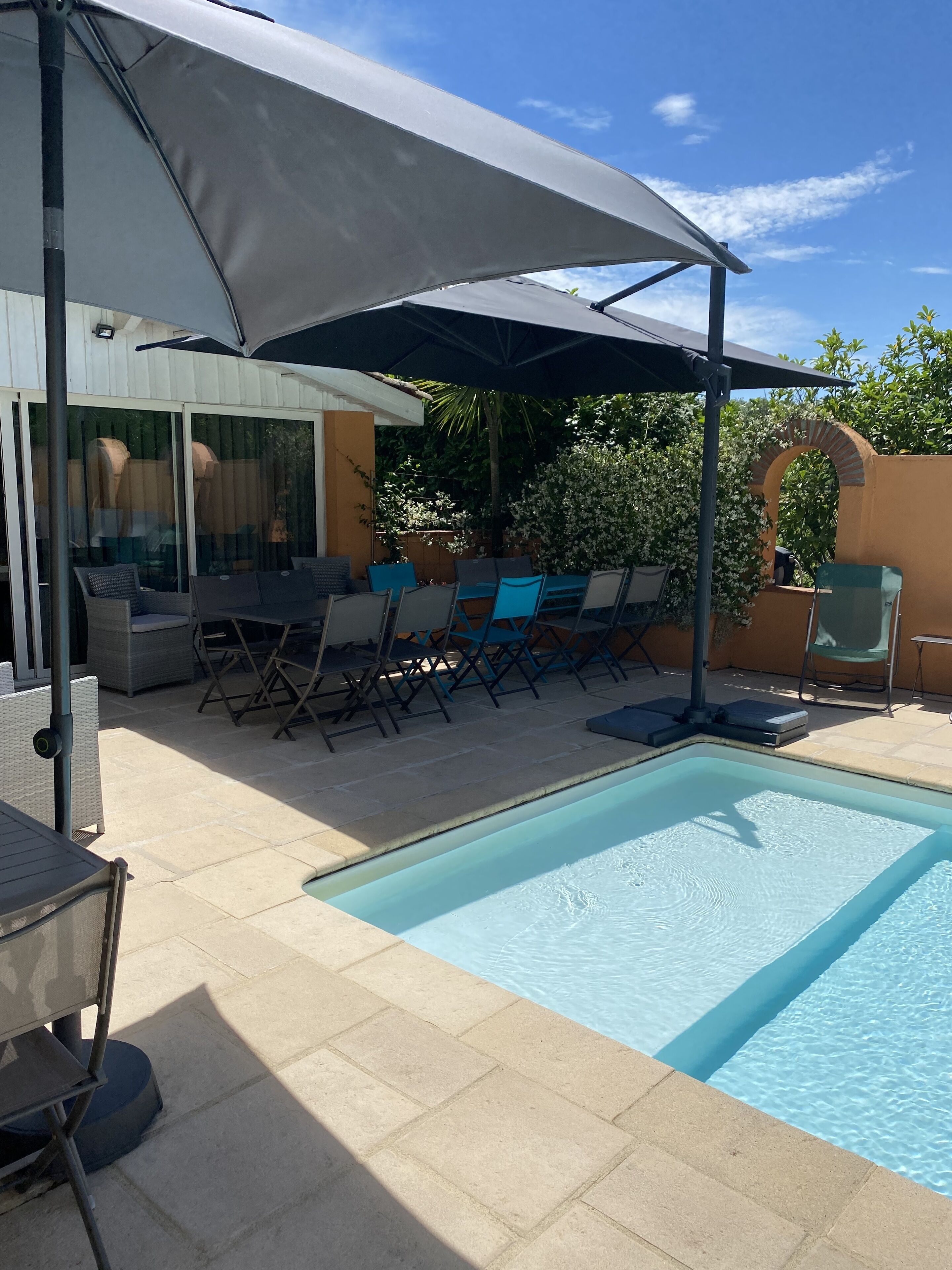 Un'area piscina con zona relax coperta, lettini e piscina.
