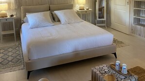 Een slaapkamer met een groot bed, een nachtkastje met een lamp, een houten hoofdbord en een hemelbed.