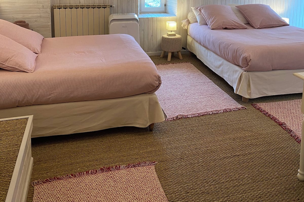 Een knus slaapkamer met twee bedden, een raam en een radiator.