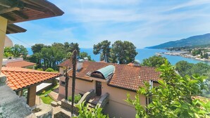 A coastal view with terracotta-roofed buildings, a clear sky, and a marina in the distance. - Villa Vosilla (Opatija)