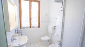 A bathroom with a sink, toilet, and bidet. - Appartamenti Le Mimose (Capoliveri)