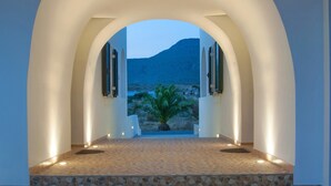 Un corridoio ad arco con vista su un paesaggio desertico e montagne.