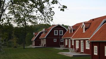 En rad röda trähus med sadeltak, vita detaljer och många fönster.