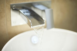 A bathroom sink with running water.
